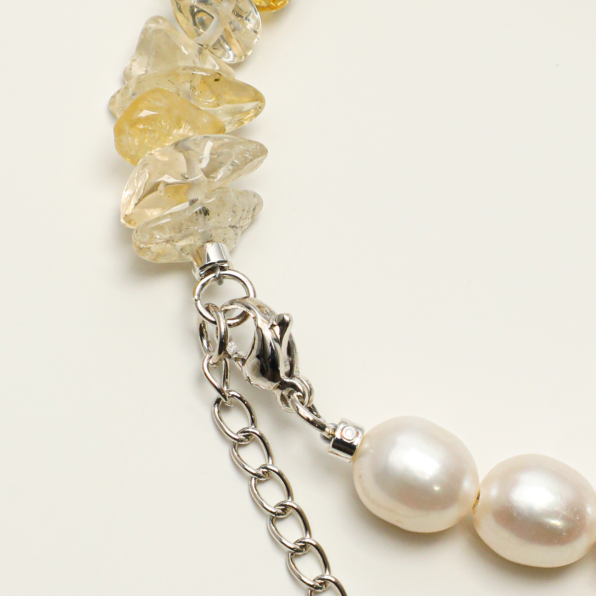 Citrine chips and freshwater pearls beside lobster clasp