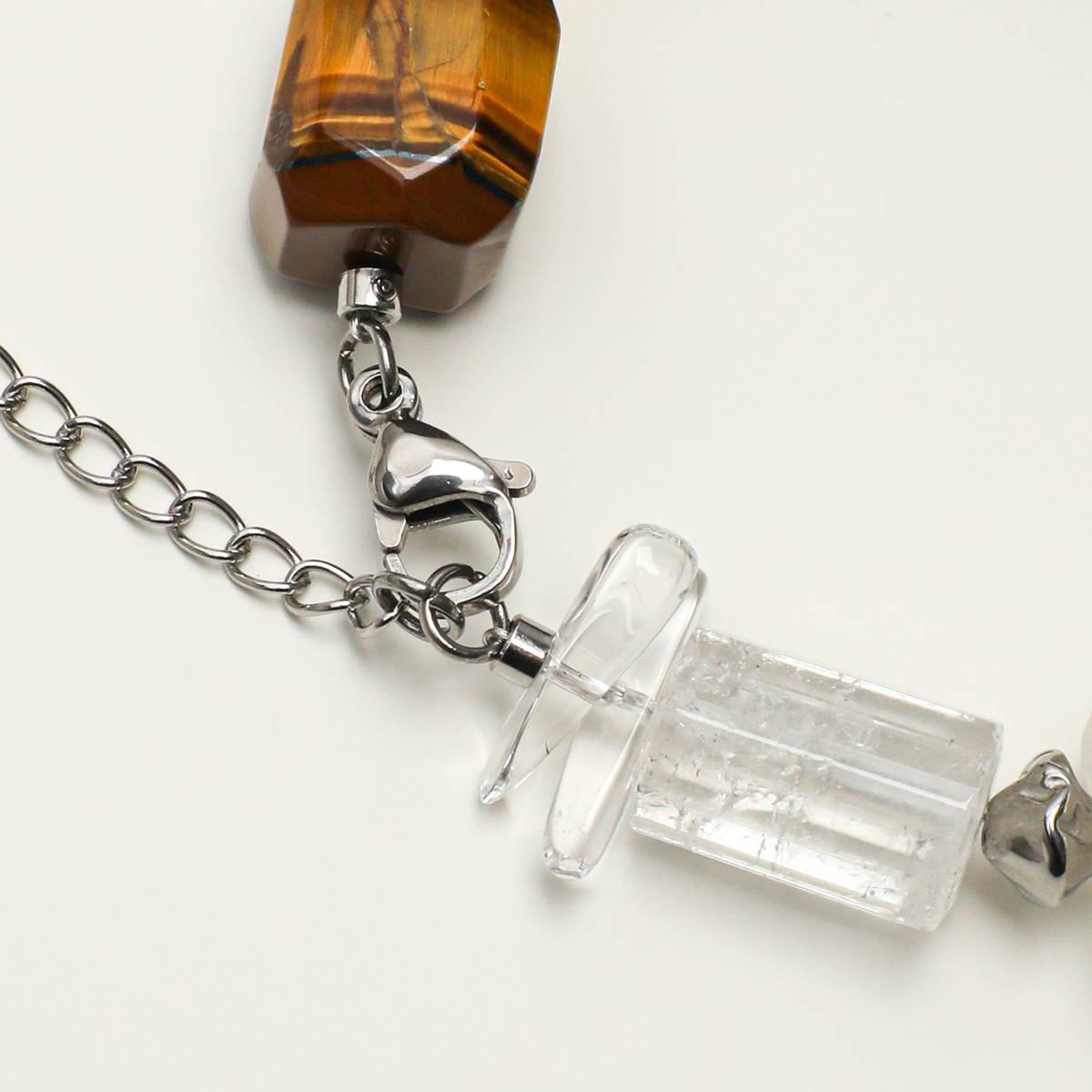Silver-plated 316L stainless steel lobster clasp, extender chain, and clear quartz detail